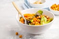 Salad with baked pumpkin and chickpeas with mustard-honey dressing in a white plate, macro. Healthy vegan food concept. Royalty Free Stock Photo
