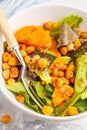 Salad with baked pumpkin and chickpeas with mustard-honey dressing in a white plate, macro. Healthy vegan food concept. Royalty Free Stock Photo