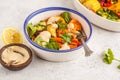 Salad with baked vegetables with tahini in white plate, white ba Royalty Free Stock Photo