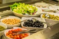Salad bar with vegetables, chickpeas, rice, olives