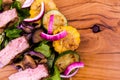 Salad with beef slices, grilled vegetables - eggplant, corn, mushrooms, sauce on a wooden board, dish Royalty Free Stock Photo