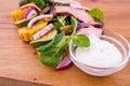 Salad with beef slices, grilled vegetables - eggplant, corn, mushrooms, sauce on a wooden board, dish Royalty Free Stock Photo