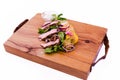 Salad with beef slices, grilled vegetables - eggplant, corn, mushrooms, sauce on a wooden board, dish. The object is isolated on a Royalty Free Stock Photo