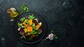 Salad: beetroot, pumpkin, corn and lettuce in a black plate on a black background. Top view.