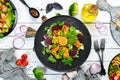 Salad: beetroot, pumpkin, corn and lettuce in a black plate on a white wooden background. Top view.