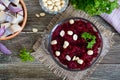 Salad from boiled beets, pieces of herring with red onion, nuts. Royalty Free Stock Photo