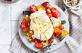 Salad with burrata cheese, cherry tomatoes and strawberry with microgreen and olive oil. Traditional Italian burrata cheese. Royalty Free Stock Photo