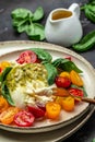 Salad burrata cheese tomatoes and green pesto. Delicious balanced food concept. superfood concept. Healthy, clean eating. Vegan or Royalty Free Stock Photo