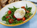 Salad with burrata italian cheese, cherry tomatoes and arugula green leaf