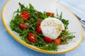 Salad with burrata italian cheese, cherry tomatoes and arugula green leaf