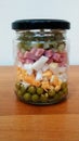 Salad in jar, peas, eggs, ham and picled cucumbers Royalty Free Stock Photo