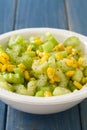 Salad celery with corn in white bowl