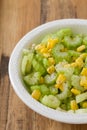 Salad celery with corn in white bowl