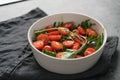 Salad with cherry tomatoes and mixed grens in white bowl on concrete background Royalty Free Stock Photo