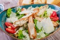 Salad with chicken breast, parmesan cheese, croutons, tomatoes, mixed greens, lettuce and glass of wine