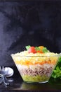 Salad with chicken liver in layers with pickles,boiled carrot, egg, cheese in a glass bowl on a black abstract Royalty Free Stock Photo