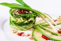Salad with chuka seaweed, avocado, cucumber, sesame seeds, pine nuts on a white plate Royalty Free Stock Photo