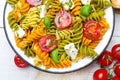 Salad with colorful pasta, cherry tomatoes, feta cheese and fresh basil Royalty Free Stock Photo