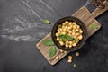 Salad with cooked or canned chickpeas and fresh mint in black bowl on rustic wooden board