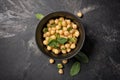 Salad with cooked or canned chickpeas and fresh mint in black bowl