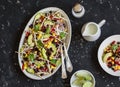 Salad with corn, beans, avocado and tortilla. Mexican black bean salad. On a dark background