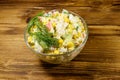 Salad with crab sticks, sweet corn, cucumber, eggs, rice and mayonnaise on wooden table Royalty Free Stock Photo