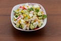 Salad with crab sticks, sweet corn, cucumber and eggs on wooden table Royalty Free Stock Photo