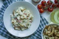 Salad with crackers, crab sticks, chicken fillet, fresh herbs and hard cheese seasoned with mayonnaise butter served in a white