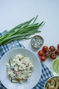 Salad with crackers, crab sticks, chicken fillet, fresh herbs and hard cheese seasoned with mayonnaise butter served in a white