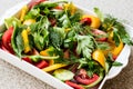 Salad with dill, yellow pepper, red pepper, parsley, tomato and cucumber in white bowl.