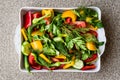 Salad with dill, yellow pepper, red pepper, parsley, tomato and cucumber in white bowl.