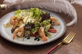 Salad with eggs and shrimps on plate, metal fork