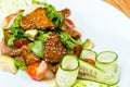 Salad of fresh cucumbers and tomatoes fried meat on a wooden table Royalty Free Stock Photo