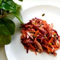 Salad of fresh grated carrots, beets, onions, meat, seasoned with pumpkin seeds.
