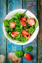 Salad with fresh spinach and strawberries with balsamic sauce and sesame