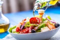 Salad. Fresh summer lettuce salad.Healthy mediterranean salad olives tomatoes parmesan cheese and prosciutto. pouring olive oil Royalty Free Stock Photo