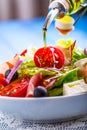 Salad. Fresh summer lettuce salad.Healthy mediterranean salad olives tomatoes parmesan cheese and prosciutto. pouring olive oil Royalty Free Stock Photo