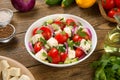 Salad with fresh tomatoes, cucumbers, red onions and feta cheese in a white salad bowl on a rustic wooden table. Royalty Free Stock Photo