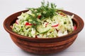 Salad from fresh vegetables: cabbage, radish, cucumber, onion and dill, in a brown salad bowl Royalty Free Stock Photo