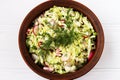 Salad from fresh vegetables: cabbage, radish, cucumber, onion and dill, in a brown salad bowl, Top view Royalty Free Stock Photo