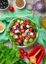 Salad with fresh vegetables, herbs, olives and cheese on the background of the ingredients Royalty Free Stock Photo