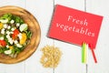 salad of fresh vegetables and notepad with text & x22;Fresh vegetables& x22;