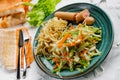 Salad of fresh vegetables on a plate with leaves, next to toasted pasta spaghetti with egg and meat sausage, a Hearty lunch, every Royalty Free Stock Photo