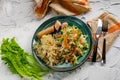 Salad of fresh vegetables on a plate with leaves, next to toasted pasta spaghetti with egg and meat sausage Royalty Free Stock Photo