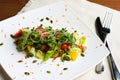 Salad with fresh vegetables, pumpkin seeds, oranges on the white plate Royalty Free Stock Photo