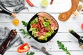 Salad of fresh vegetables and sausages in a black plate. On a wooden background. Royalty Free Stock Photo