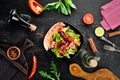 Salad of fresh vegetables and sausages in a black plate. On a wooden background. Royalty Free Stock Photo