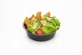 Salad with fried chicken strips and sliced parmesan cheese in a plastic take away bowl on white background Royalty Free Stock Photo