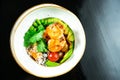 Salad with fried shrimp, rice, avocado, green beans and cherry tomatoes in a yellow bowl on a dark background. Seafood. Healthy Royalty Free Stock Photo