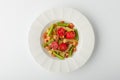 Salad with fusilli pasta with shrimps in a ceramic plate on a white background